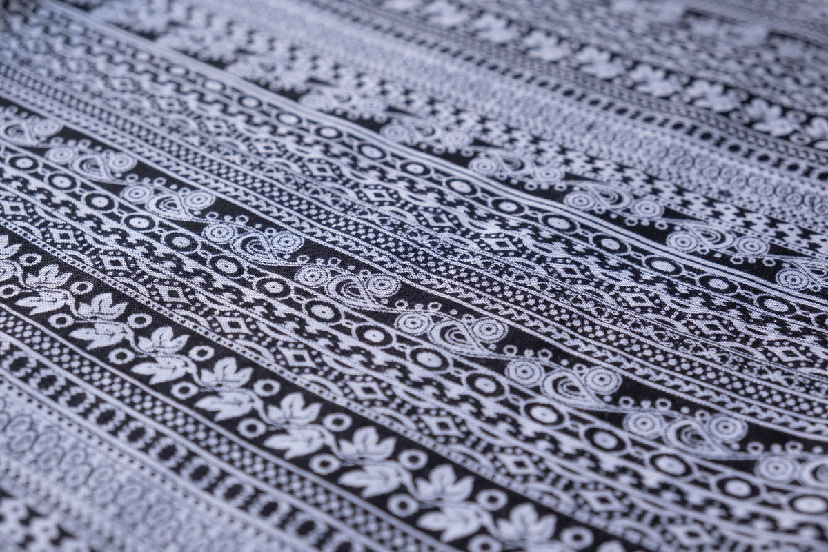 Close-up of gray printed rayon fabric with repeating folk geometric pattern